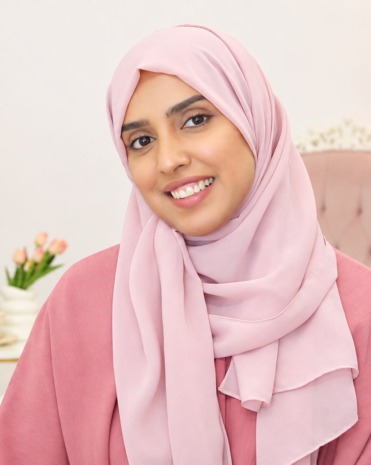 Rana, an ATLU Quran coach in a soft pink hijab, smiling in a warm cream-toned room in Madinah